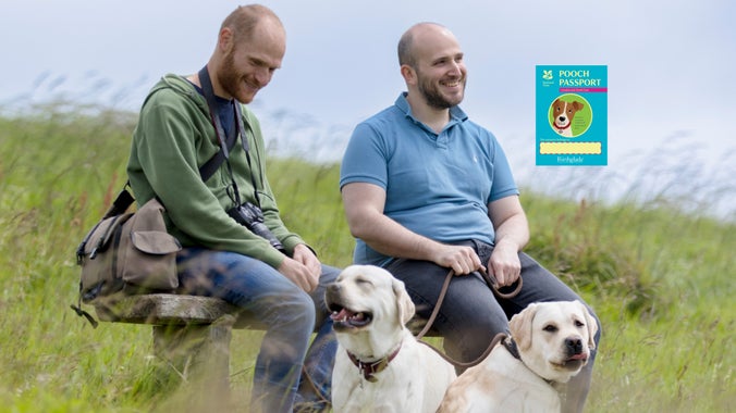 Image of two men and their dogs taking a well-earned break from their walk at the White Cliffs of Dover